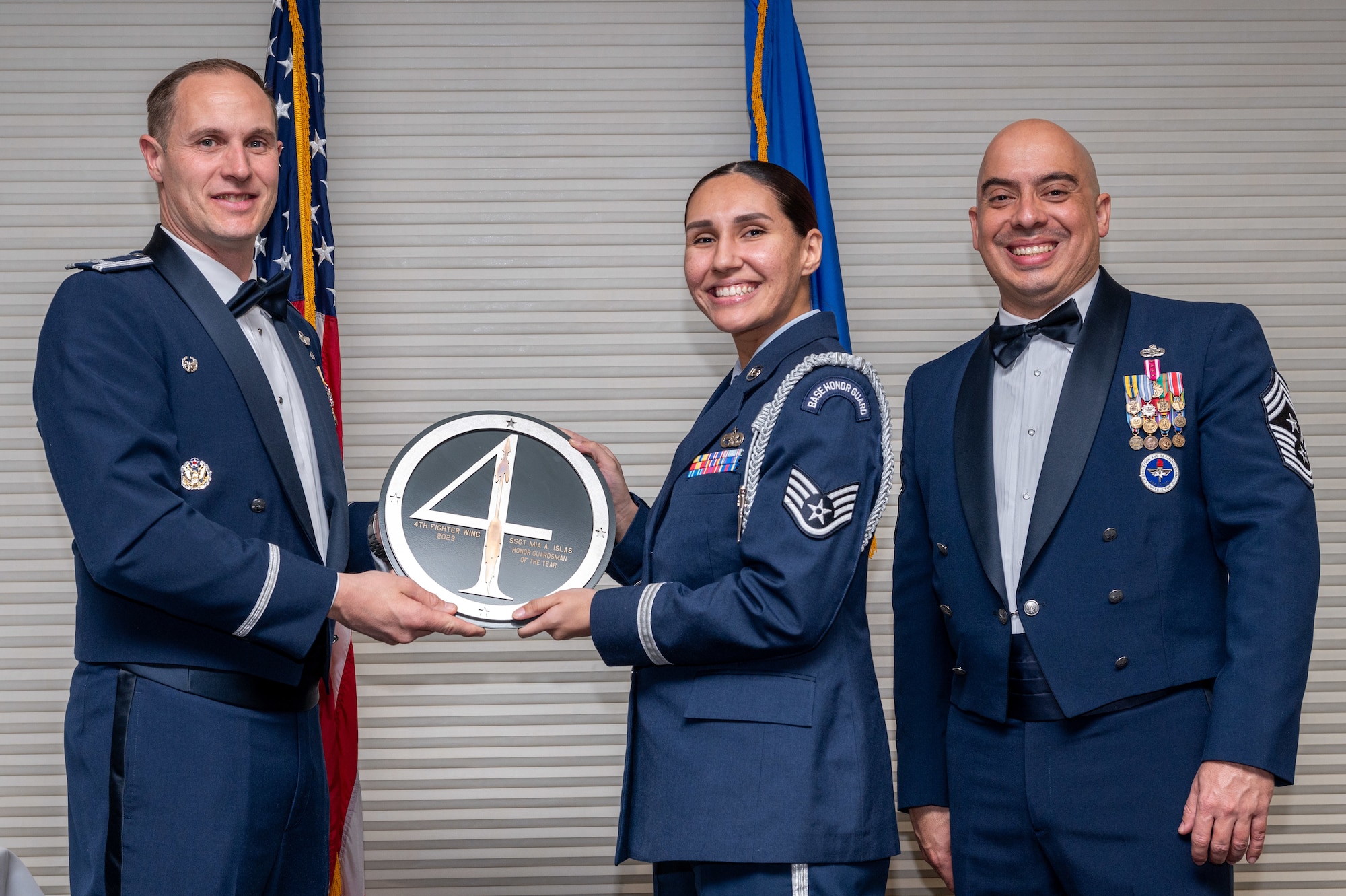 Staff Sgt. Mia Islas, center, 4th Support Squadron non-commissioned officer in charge of honor guard, receives the Honor Guardsman of the Year Award from Col. Lucas Teel, 4th Fighter Wing commander and Chief Master Sgt. Peter Martinez, 4 FW command chief, during the 4 FW Annual Awards ceremony and banquet at Seymour Johnson Air Force Base, North Carolina, Feb. 9, 2024. Annual Awards are awarded to Airmen and civilians in 13 different categories, including Volunteer of the Year, Senior Non-Commissioned Officer of the Year, Key Spouse of the Year, Airman of the Year and more. (U.S. Air Force photo by Senior Airman Sabrina Fuller-Judd)