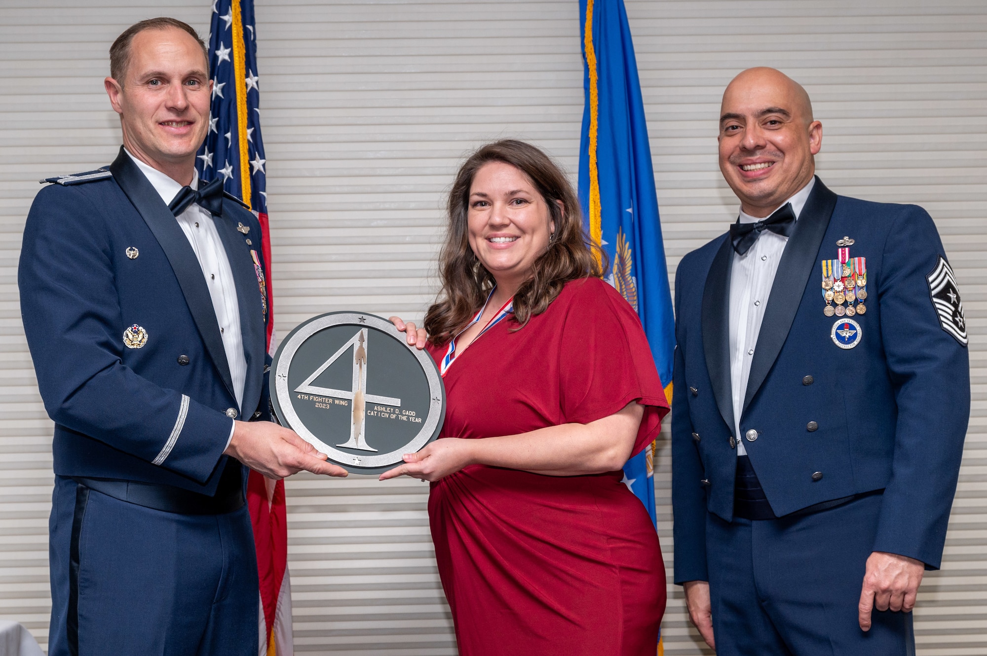 Ashley Gadd, center, 4th Wing Staff Agency administrative discharge clerk and victim witness assistance program coordinator, receives the Category 1 Civilian of the Year Award from Col. Lucas Teel, 4th Fighter Wing commander and Chief Master Sgt. Peter Martinez, 4 FW command chief, during the 4 FW Annual Awards ceremony and banquet at Seymour Johnson Air Force Base, North Carolina, Feb. 9, 2024. Annual Awards are awarded to Airmen and civilians in 13 different categories, including Volunteer of the Year, Senior Non-Commissioned Officer of the Year, Key Spouse of the Year, Airman of the Year and more. (U.S. Air Force photo by Senior Airman Sabrina Fuller-Judd)