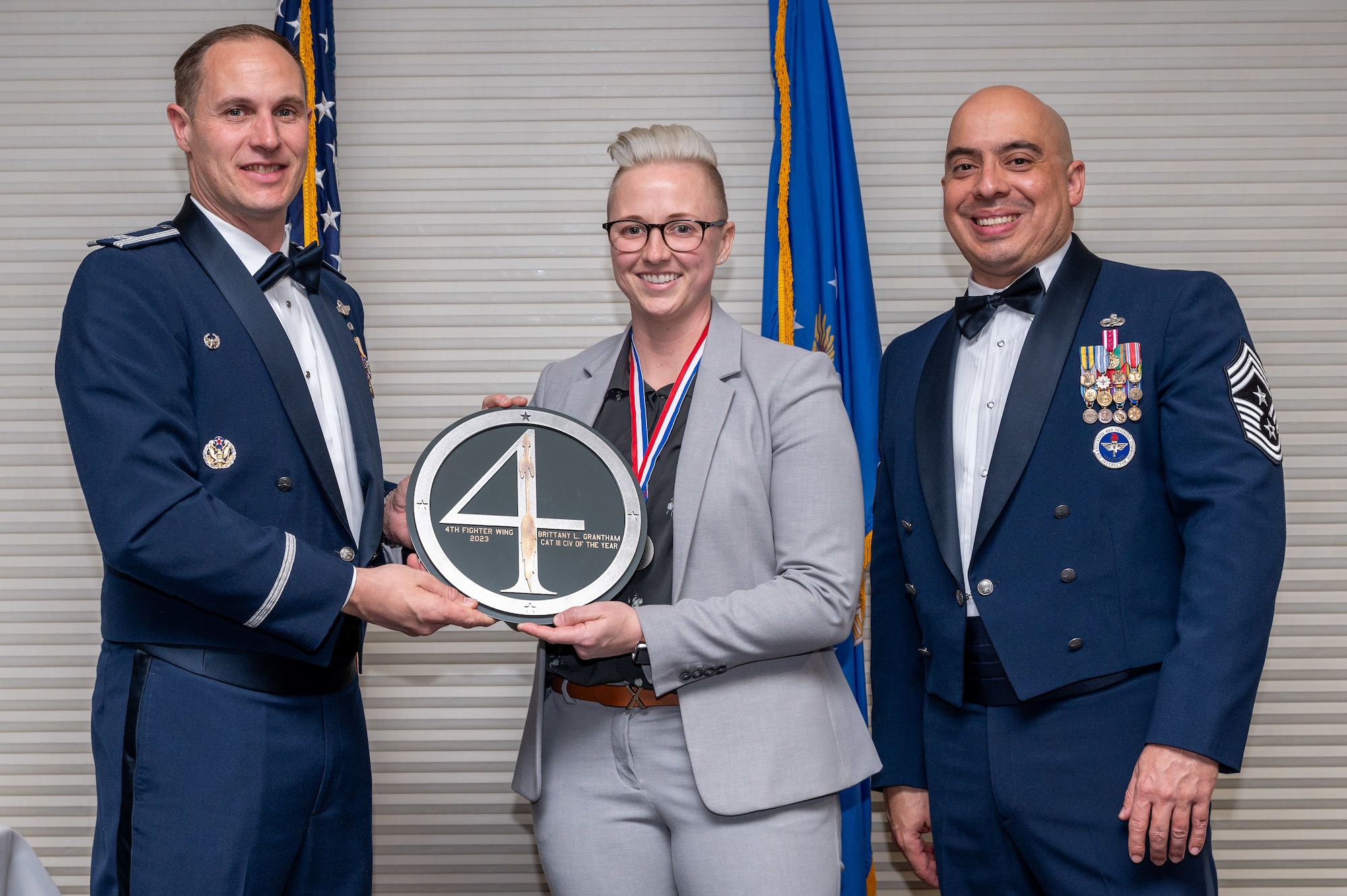 Brittany Grantham, center, 4th Support Squadron Community Services flight chief, receives the Category 3 Civilian of the Year Award from Col. Lucas Teel, 4th Fighter Wing commander and Chief Master Sgt. Peter Martinez, 4 FW command chief, during the 4 FW Annual Awards ceremony and banquet at Seymour Johnson Air Force Base, North Carolina, Feb. 9, 2024. Annual Awards are awarded to Airmen and civilians in 13 different categories, including Volunteer of the Year, Senior Non-Commissioned Officer of the Year, Key Spouse of the Year, Airman of the Year and more. (U.S. Air Force photo by Senior Airman Sabrina Fuller-Judd)