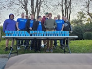 Soldiers standing behind a table with water cups ready to be handed out