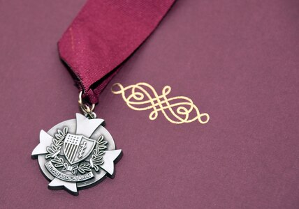 A close-up of the sterling silver medallion signifying membership in the Order of Military Medical Merit.