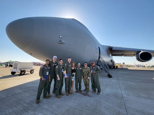 Eight U.S. Air Force recruits and eight U.S. Marine Corps recruits alongside their recruiters and Maj. Alex Layne, center left, 68th Airlift Squadron assistant director of operations pose for group photos during their initial swear in ceremony on the ramp of a C-5M Super Galaxy at the Washington’s Birthday Celebration Association Stars and Stripes Air Show Spectacular on the flightline at the Laredo International Airport in Laredo, Texas Feb. 25, 2024.