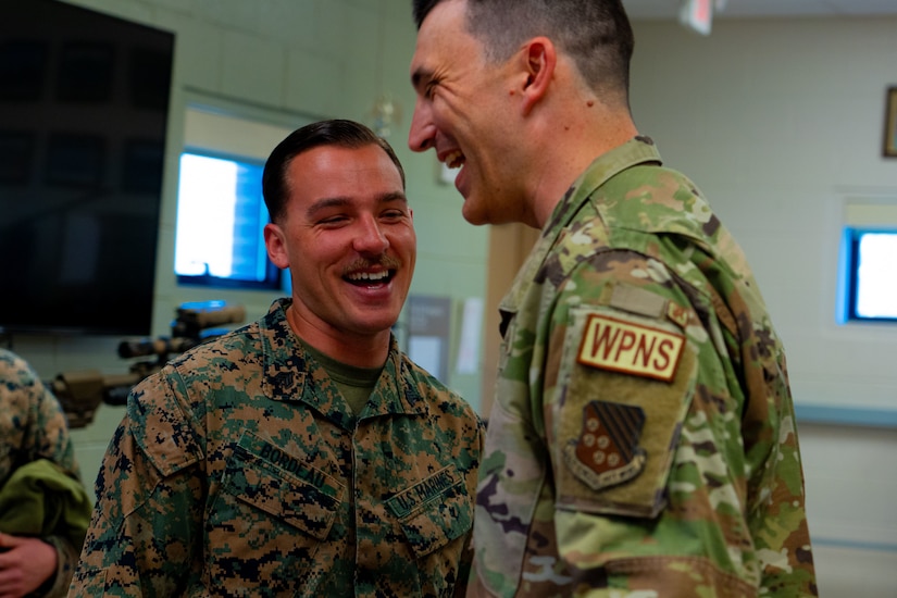 An Airman and Marine laugh.