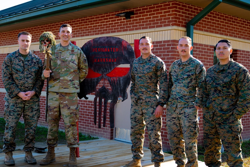 An Airman and Marines pose for a photo.