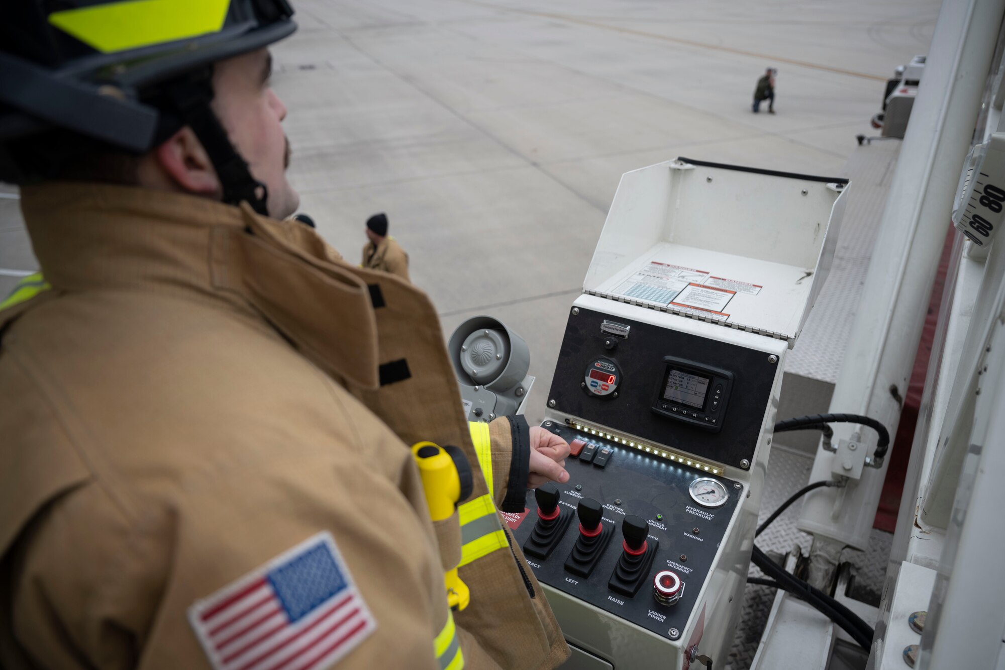 A fireman controls a firetruck ladder.