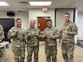 photo of women wearing U.S. Army uniform with a man wearing uniforms.