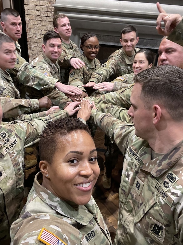 photo of women wearing U.S. Army uniform with two men wearing uniforms.