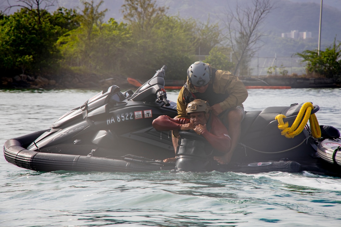 An iWaterman instructor demonstrates a single man rescue with unconscious victim for special forces students during an iWaterman Maritime Reconnaissance Vehicle (MRV) course at Marine Corps Base Hawaii, Jan. 31, 2024. iWaterman is a program that teaches students how to utilize the MRV for tactical insertions, extractions, and rescues in high surf and over the beach operations. (U.S. Marine Corps photo by Sgt. Julian Elliott-Drouin)