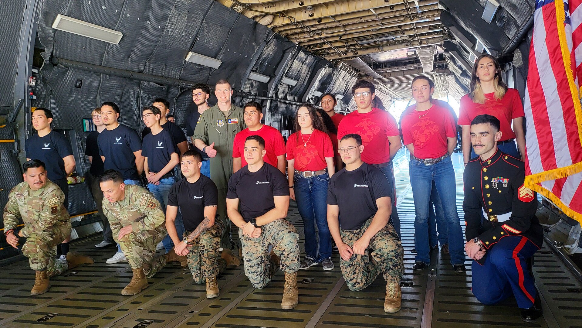 Eight U.S. Air Force recruits and eight U.S. Marine Corps recruits alongside their recruiters and Maj. Alex Layne, center left, 68th Airlift Squadron assistant director of operations pose for group photos during their initial swear in ceremony on the ramp of a C-5M Super Galaxy at the Washington’s Birthday Celebration Association Stars and Stripes Air Show Spectacular on the flightline at the Laredo International Airport in Laredo, Texas Feb. 25, 2024.