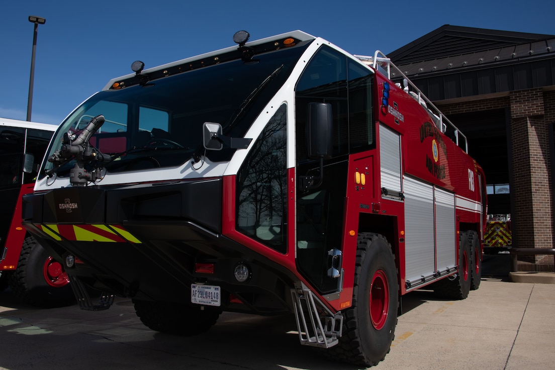 A fire truck is parked in front of a fire station.