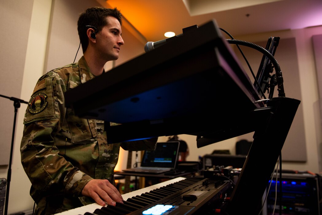 Airman plays the piano during rehearsal.