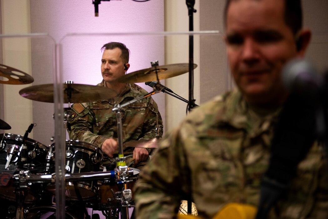 Airman plays the drums during a rehearsal.