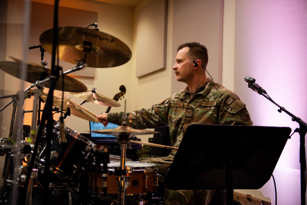 Airman plays drums during a rehearsal.