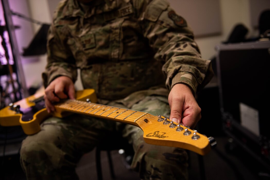 Airman tunes a musical instrument.