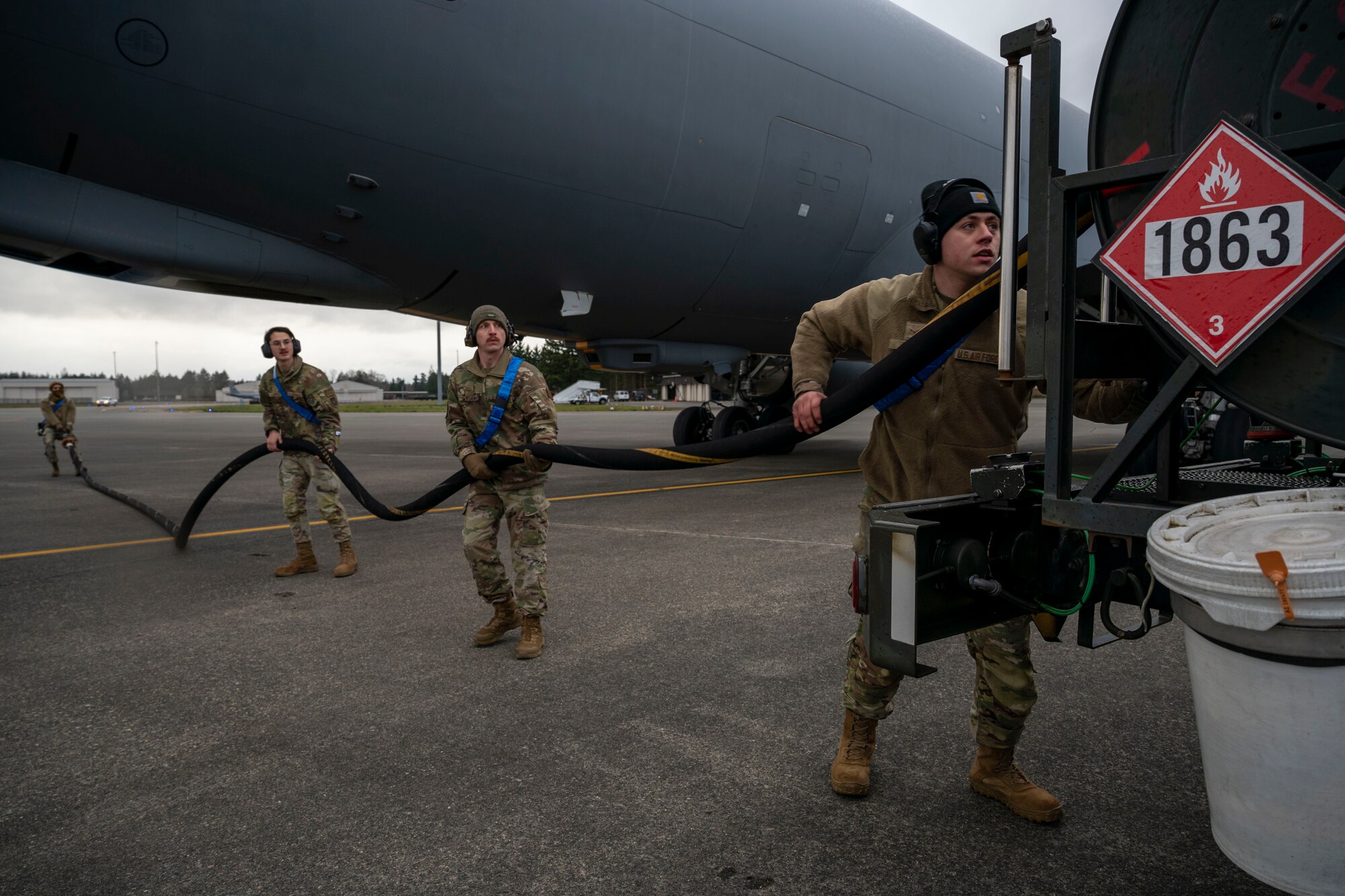 Maintenance Airmen assigned to McConnell Air Force Base, Kansas, wind up a fuels hose after refueling a KC-46 Pegasus during EXPLODEO Feb. 28, 2024, at Joint Base Lewis-McChord, Washington. EXPLODEO was a McConnell Air Force Base, Kansas, exercise that tested the 22nd and 931st Air Refueling Wings’ ability to rapidly deploy and employ into a theater. (U.S. Air Force photo by Airman 1st Class Gavin Hameed)
