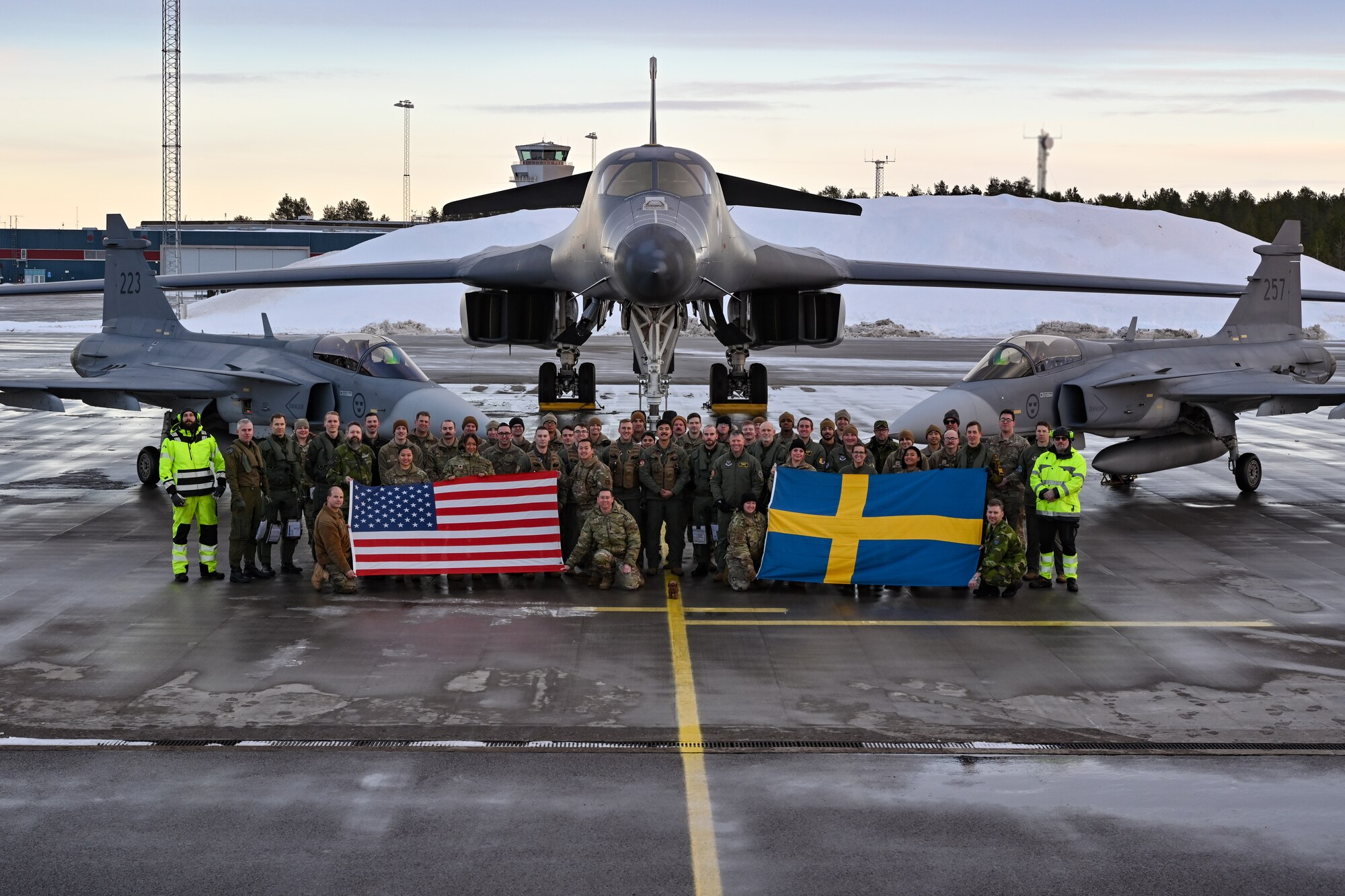 U.S. Air Force Airmen assigned to the 28th Bomb Wing, Ellsworth Air Force Base, South Dakota, pose for a group photo alongside Swedish military personnel in front of a B-1B Lancer and two Saab JAS 39 Gripens at Luleå-Kallax Air Base, Sweden, Feb. 26, 2024, during Bomber Task Force 24-2. These BTF missions are representative of the U.S.' extended deterrent commitment to its Allies and partners and enhance regional security. BTF operations provide U.S. leaders with strategic options to assure Allies and partners, while deterring potential adversary aggression across the globe. (U.S. Air Force photo by Staff Sgt. Jake Jacobsen)