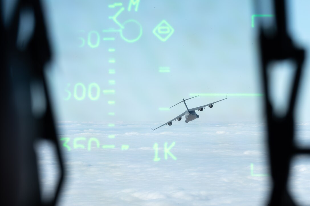 Two C-17 Globemaster IIIs trade leading and following positions within their flight path