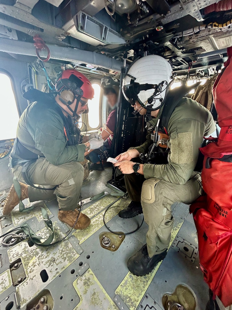 The crew of a U.S. Navy's Helicopter Sea Combat Squadron 25 (HSC-25) see to the medical care of a 26-year-old Filipino mariner following a hoist from his vessel 100 nautical miles offshore to Guam on March 2, 2024. Responders initiated the operation after notification the mariner, aboard the 850-foot Liberian-flagged container ship Carmell 1, initially located 400 nautical miles northwest of Guam, exhibited severe abdominal issues. (U.S. Navy photo)