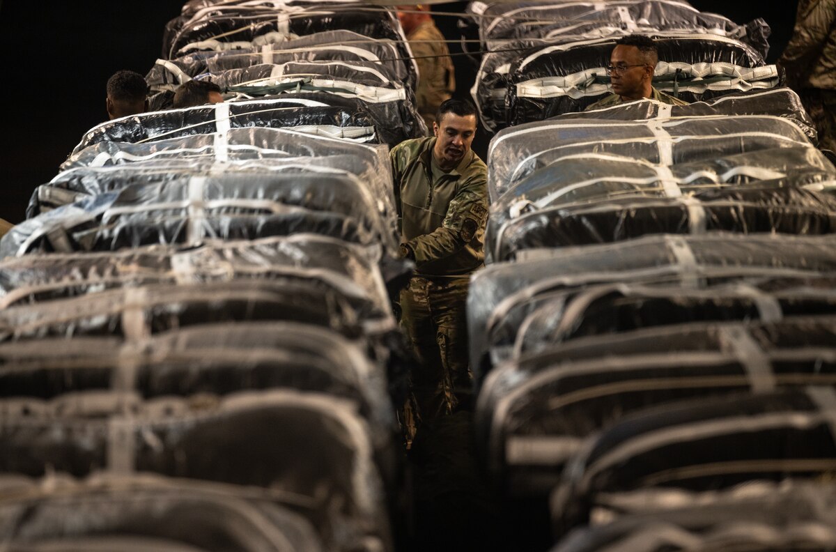 Service members secure humanitarian aid onto a cargo aircraft at an undisclosed location within the U.S. Central Command area of responsibility.