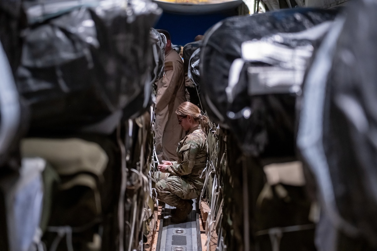 A Soldier secures straps on humanitarian aid pallets at an undisclosed location in Southwest Asia.