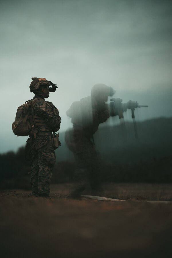 U.S. Marine Corps Lance Cpl. Christian Montemayor, left, a fire support Marine with 5th Air Naval Gunfire Liaison Company, III Marine Expeditionary Force Information Group, observes a Marine performing a nighttime course of fire during a Marine Corps Combat Marksmanship Program range as part of 2nd Brigade Platoon’s field exercise on Camp Hansen, Okinawa, Japan, Feb. 14, 2024. This CMP allows Marines to maintain weapon proficiency by engaging targets in a competitive environment with primary and secondary weapon systems.  5th ANGLICO Marines refined their marksmanship fundamentals through advanced marksmanship training which enhanced their lethality. Montemayor is a native of San Diego. (U.S. Marine Corps photo by Staff Sgt. Manuel A. Serrano)