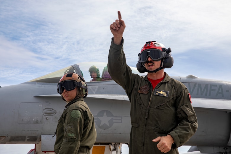 U.S. Marine Corps Sgt. Micah Leone, right, an aviation ordnance technician with Marine Fighter Attack Squadron (VMFA) 232, passes word on the flightline at Andersen Air Force Base, Guam, Jan. 26, 2024. Nicknamed the “Red Devils,” VMFA-232 traveled from Marine Corps Air Station Iwakuni, Japan to Guam as a part of their Aviation Training Relocation Program deployment to train multilaterally with allies and partners, and enhance the squadron’s combat readiness. (U.S. Marine Corps photo by Lance Cpl. David Getz)