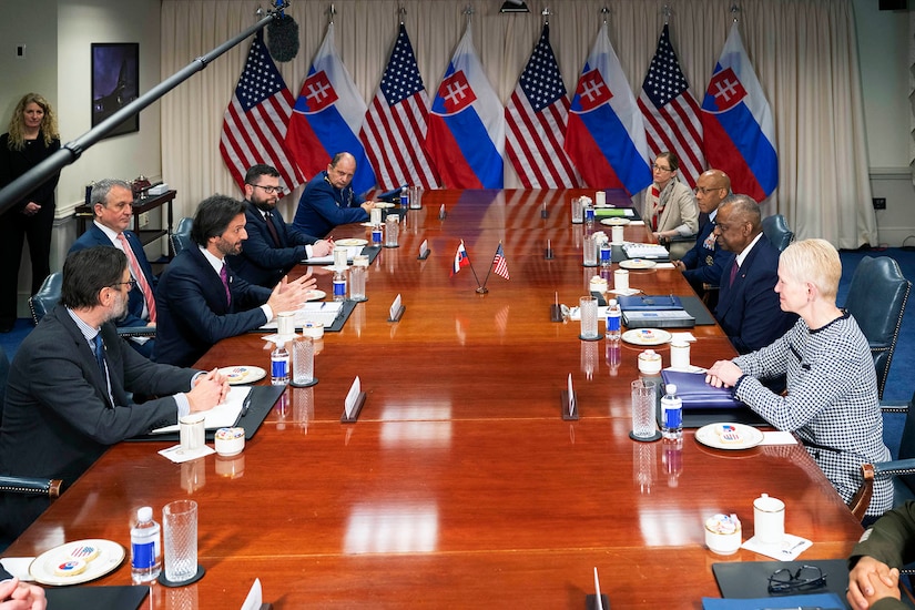 A group of people meet around a large table.