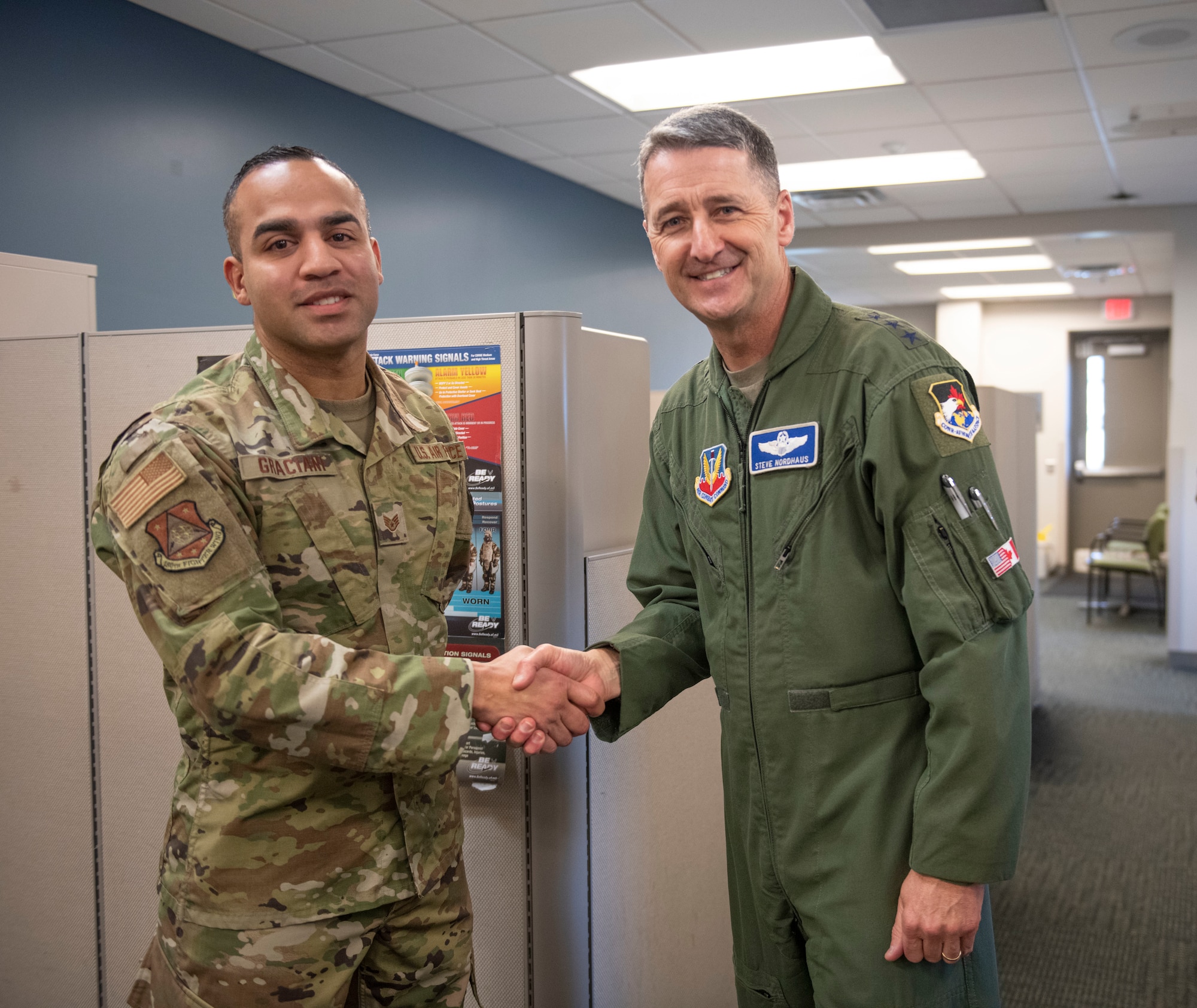 U.S. Air Force Lt. Gen. Steven S. Nordhaus, 1st Air Force commander, presents a challenge coin to U.S. Air Force Staff Sgt. Xavier Graciani, a security forces Airman assigned to the 180th Fighter Wing, after coining him, during a visit with the 180FW, in Swanton, Ohio, Feb. 1, 2024. Graciani was coined for his exemplary performance, maintaining the highest levels of proficiency and readiness. (U.S. Air National Guard photo by Airman 1st Class Nicholas Battani)