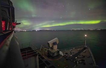 USS Gunston Hall (LSD 44) passes under the northern lights while transiting the Andfjorden waterways.