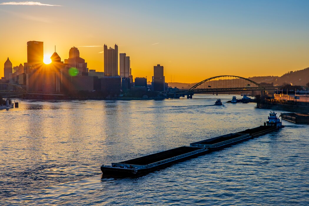 Towboats positioning barges of coal and other commodities on the Ohio River in Pittsburgh at sunrise.