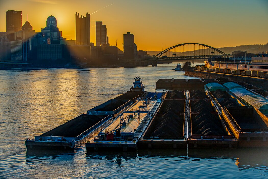 Towboats positioning barges of coal and other commodities on the Ohio River in Pittsburgh at sunrise.