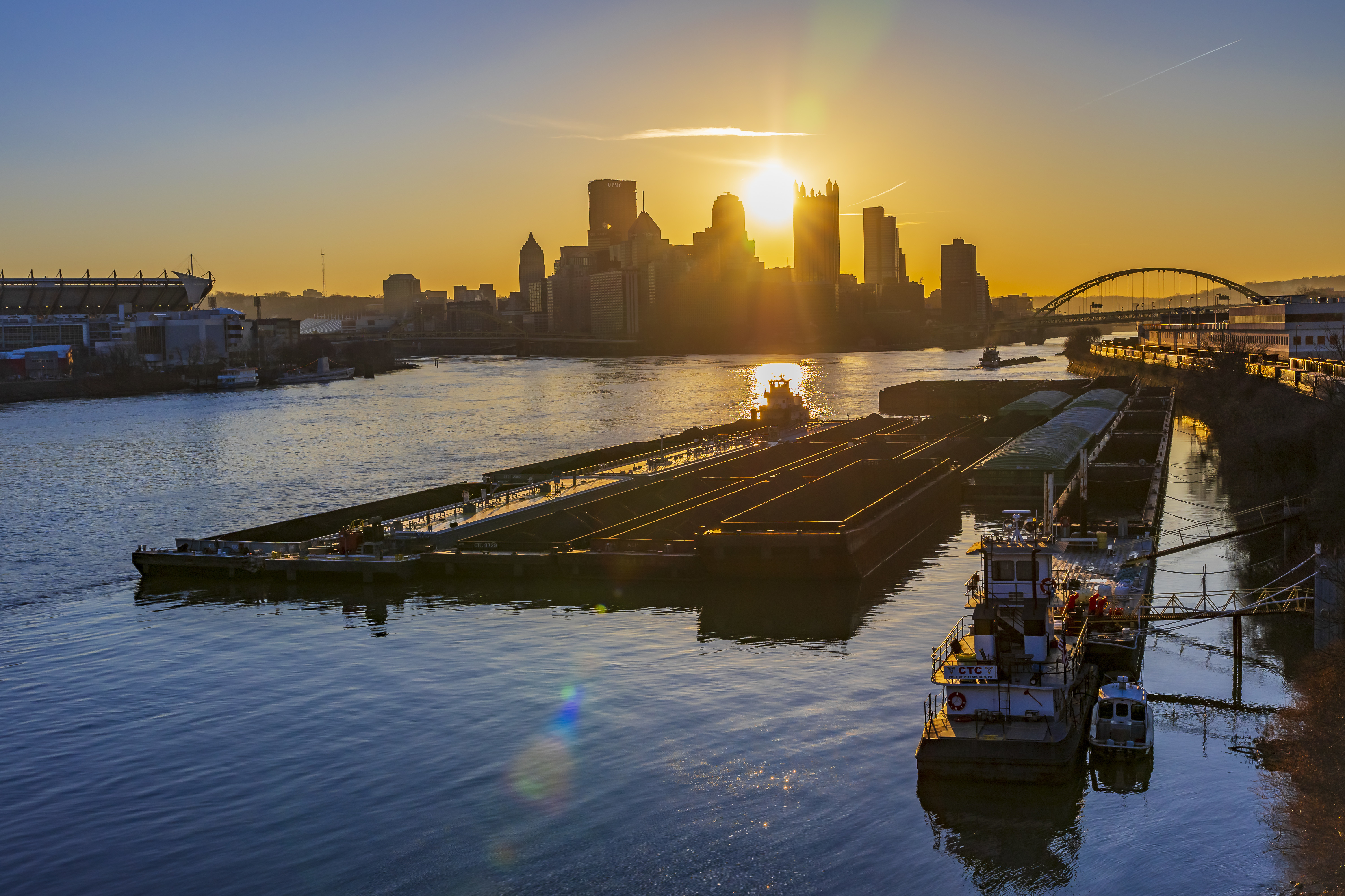 Towboats positioning barges of coal and other commodities on the Ohio River in Pittsburgh at sunrise.