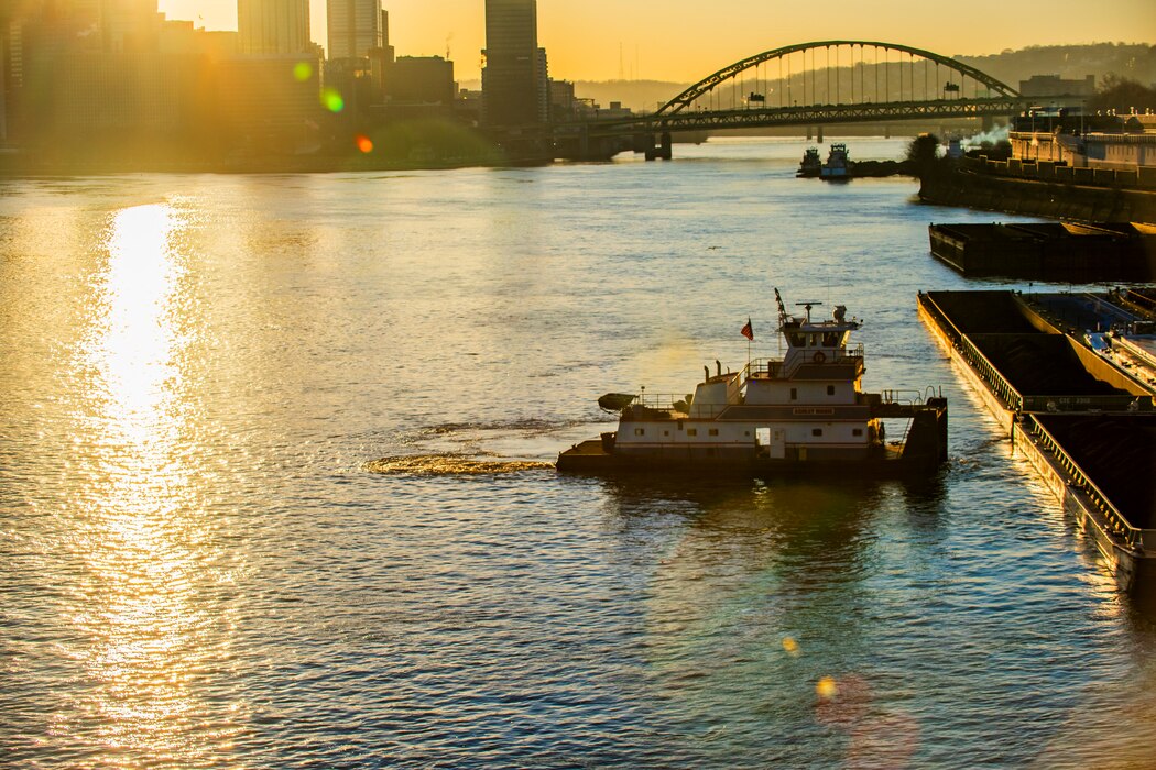 Towboats positioning barges of coal and other commodities on the Ohio River in Pittsburgh at sunrise.