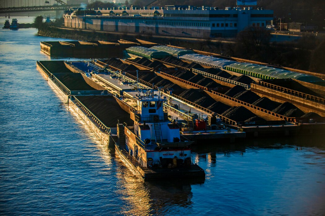 Towboats positioning barges of coal and other commodities on the Ohio River in Pittsburgh at sunrise.