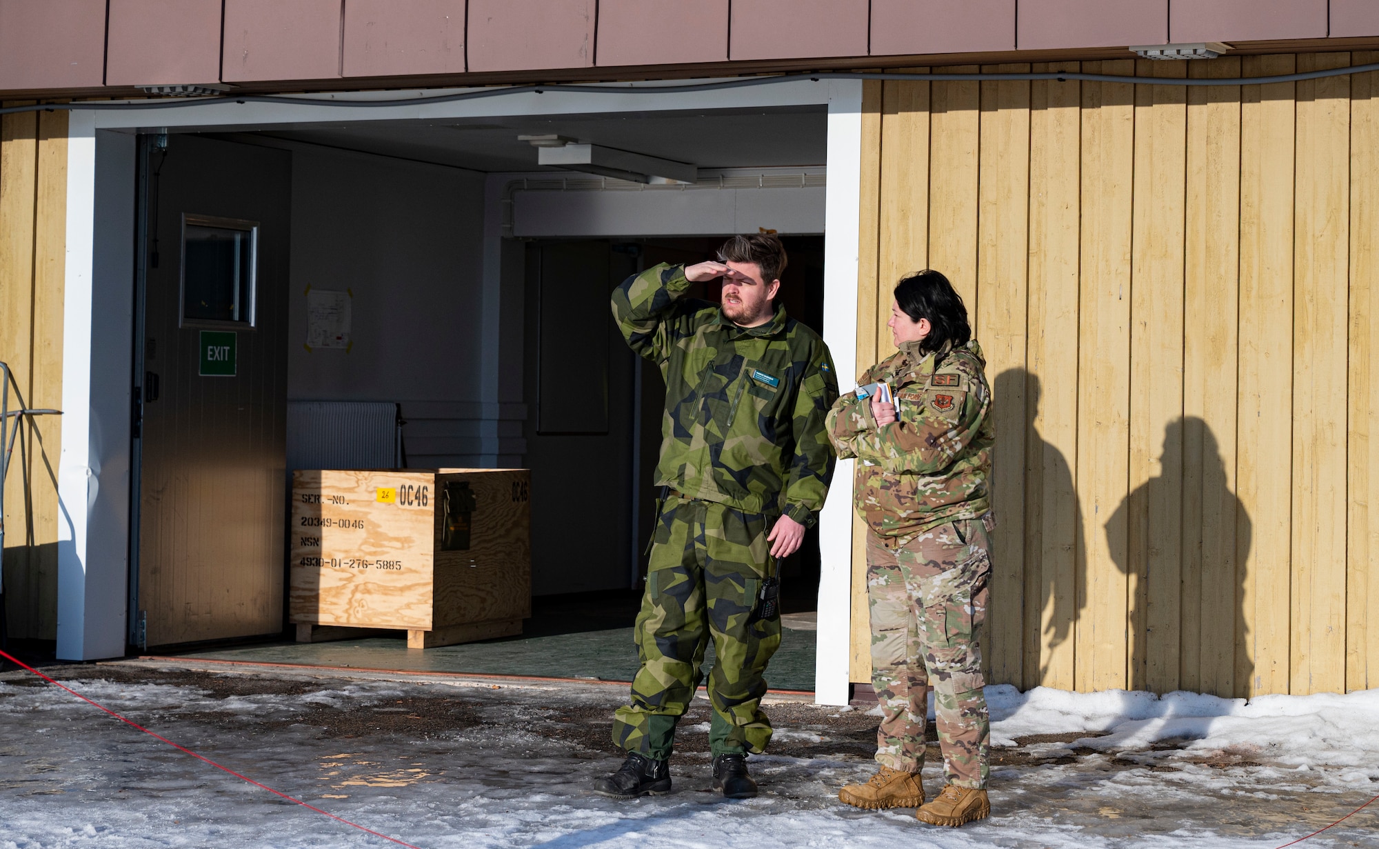 From left, Swedish Air Force Staff Sgt. Markus Saarholm, F 21 Norbotten Wing force protection control officer, and U.S. Air Force Master Sgt. Natalie Cardenas, 422nd Security Forces Squadron standardization & evaluation NCOIC and Bomber Task Force 24-2 force protection lead, chat while on a break during BTF 24-2 at Luleå-Kallax Air Base