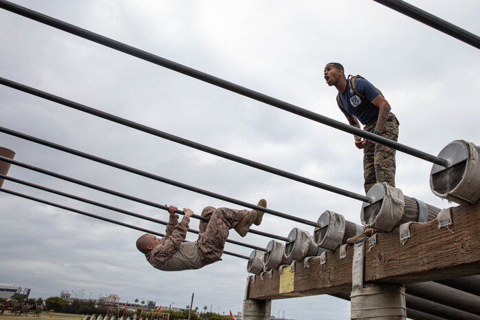 U.S Marine Corps Sgt. Immanuel Chrisp, a drill instructor with Kilo Company, 3rd Recruit Training Battalion, motivates recruits during an obstacle course training event at Marine Corps Recruit Depot San Diego, California, Feb. 29, 2024. The o-course includes obstacles that recruits must overcome to enhance strength, agility, and confidence. (U.S. Marine Corps photo by Lance Cpl. Sarah M. Grawcock)