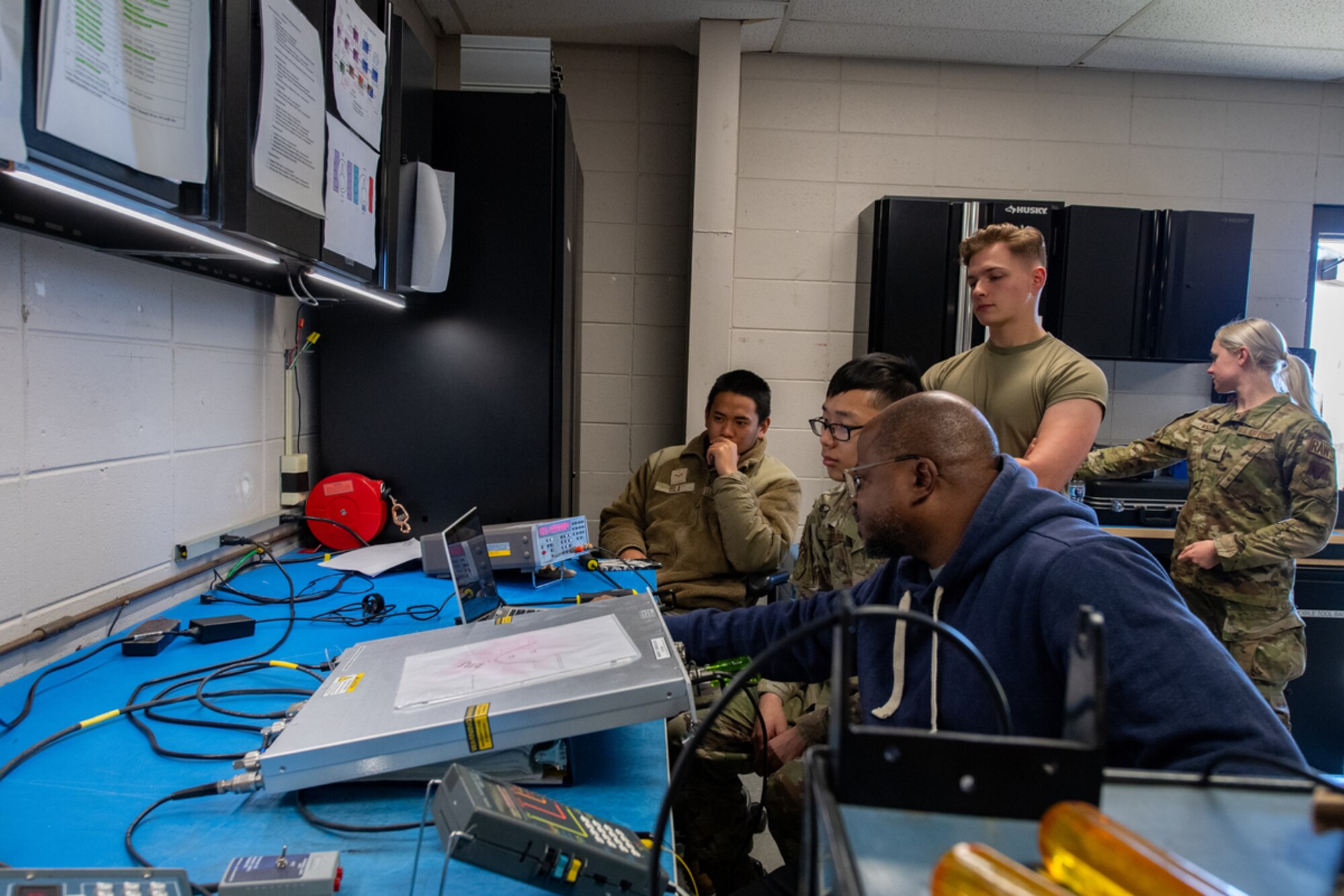 Airmen sit together to discuss electrical systems