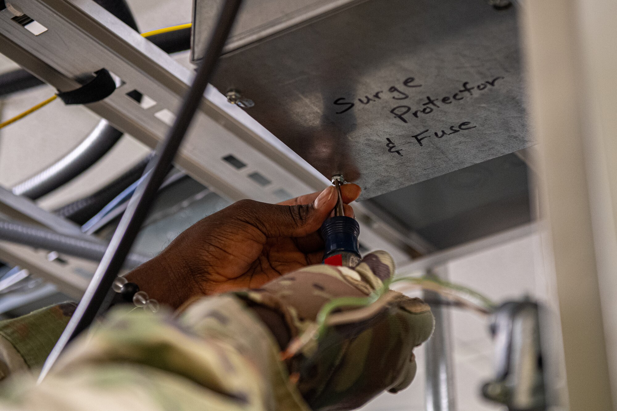 An Airman works on electric wires