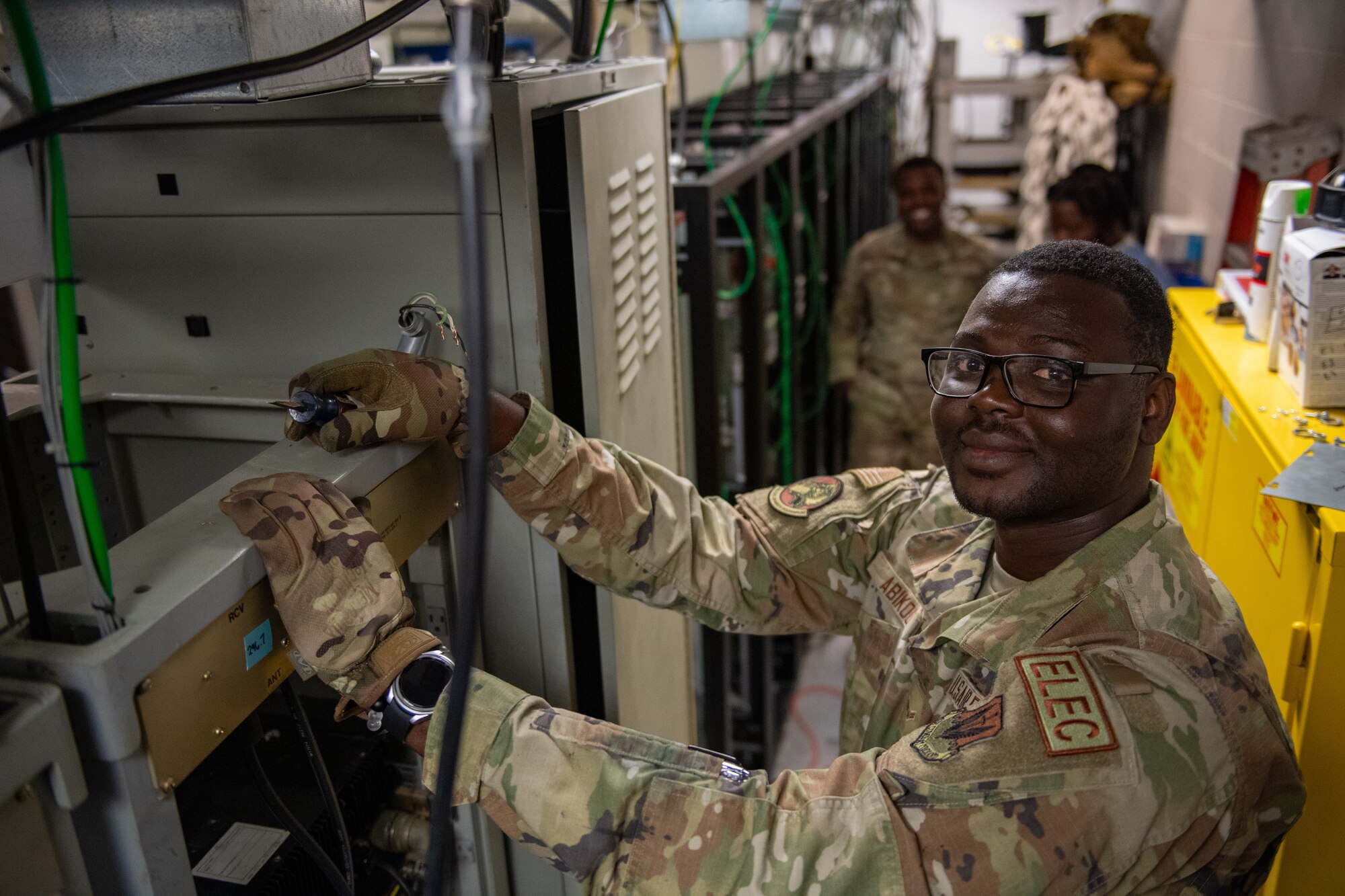 Airmen poses for a photo while doing his job