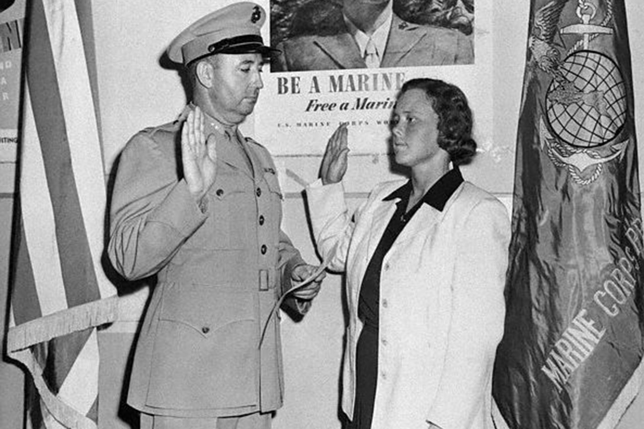 A person is sworn into the military in a black and white photo.