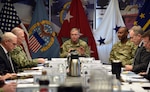 Military and civilian people seated around a table.