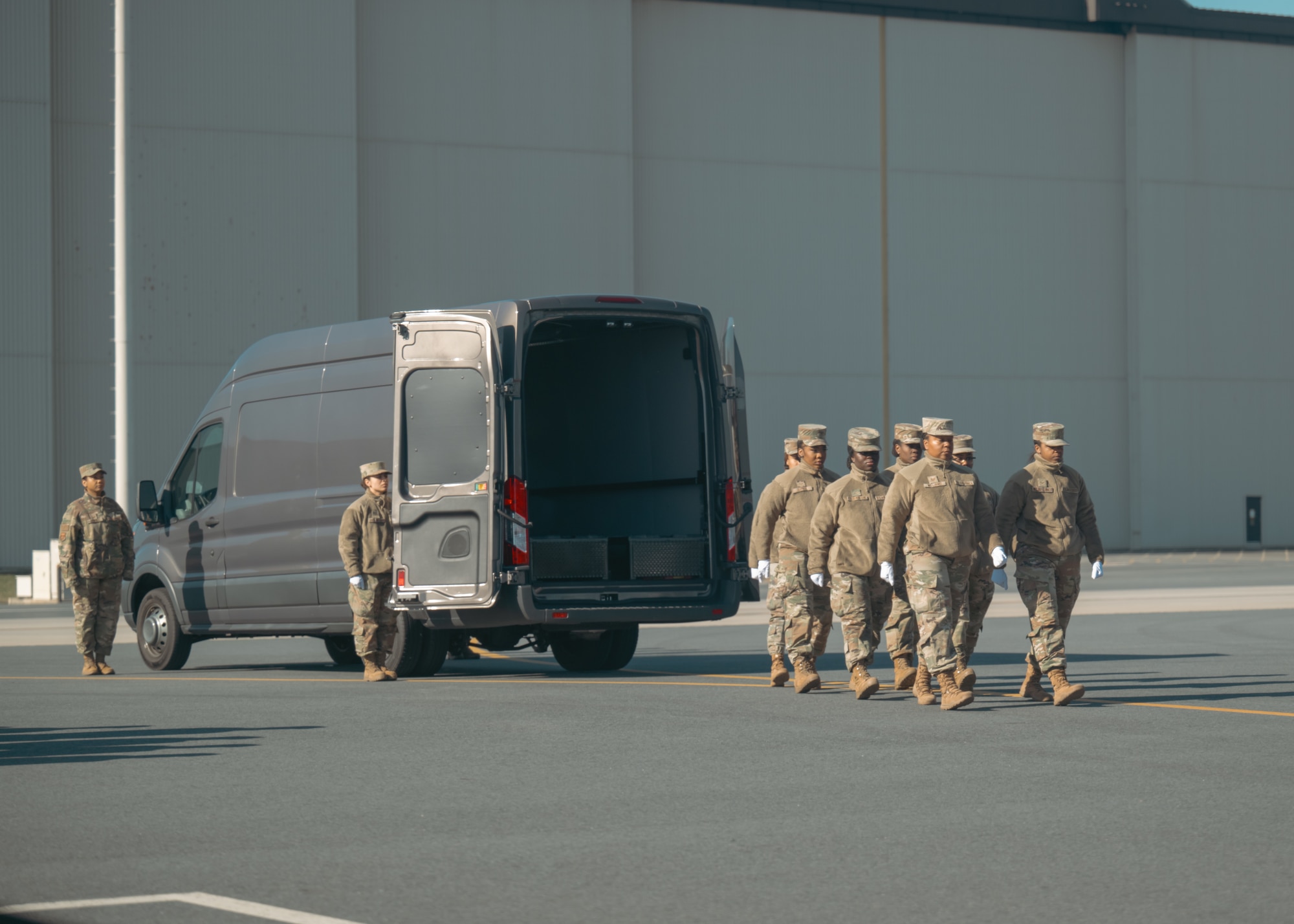A group of female service members march in formation during a dignified transfer ground training.