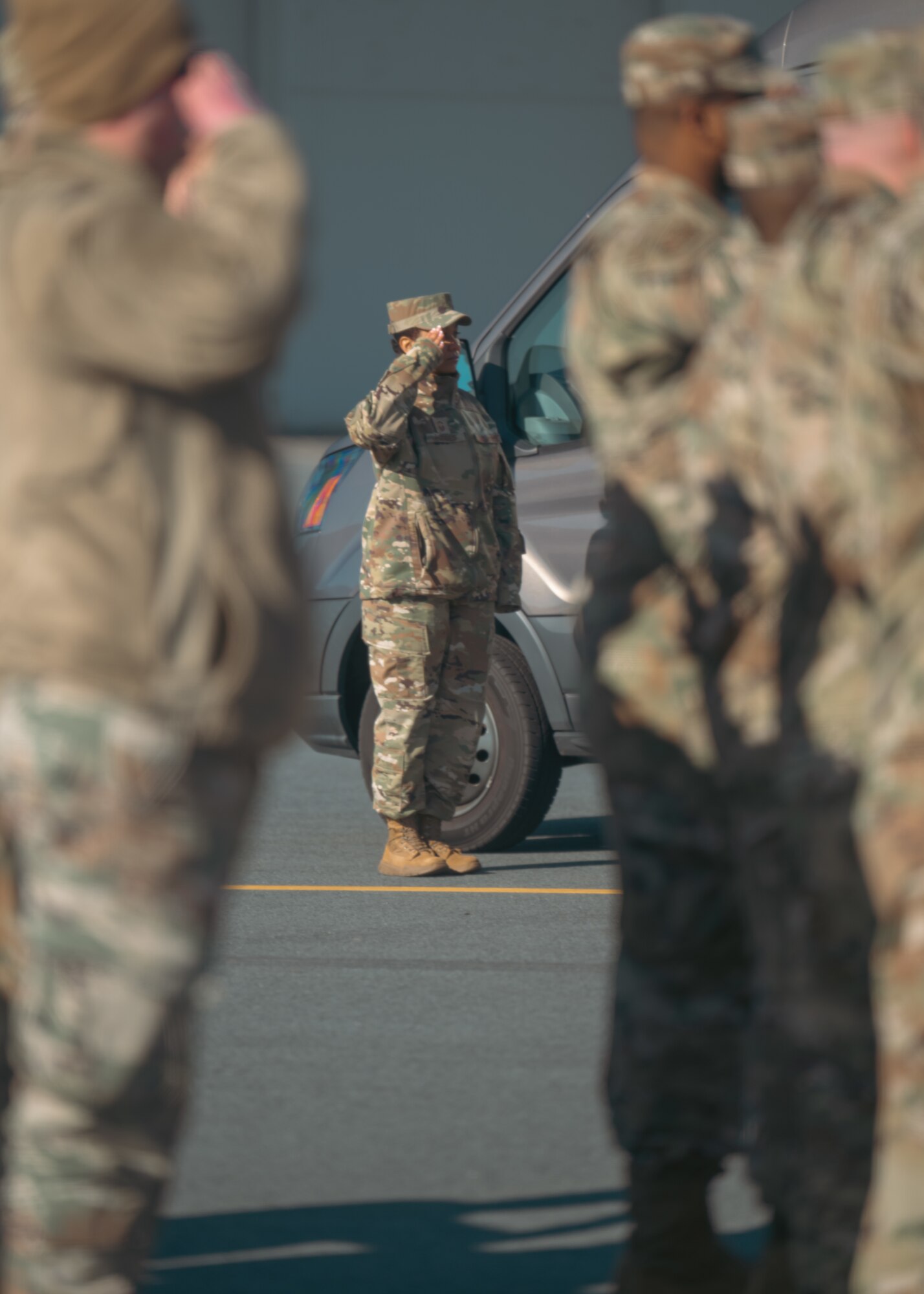 A female service member salutes during a dignified transfer ground training.