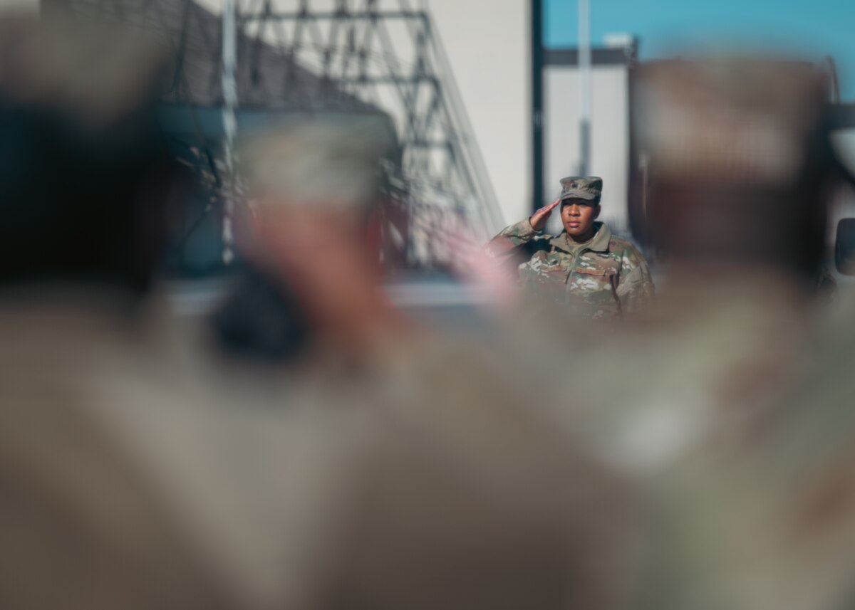 A female service member salutes during a Dignified Transfer ground training.