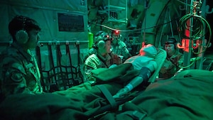 Airman looks at a medical monitor on an aircraft.