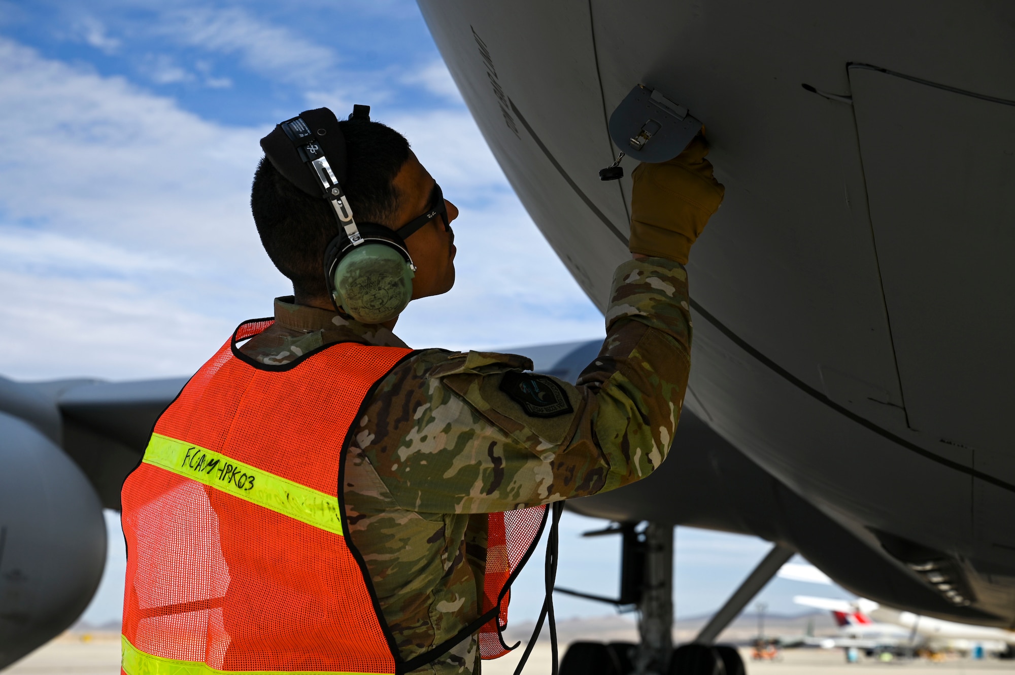 A man connects a cable to a jet. 