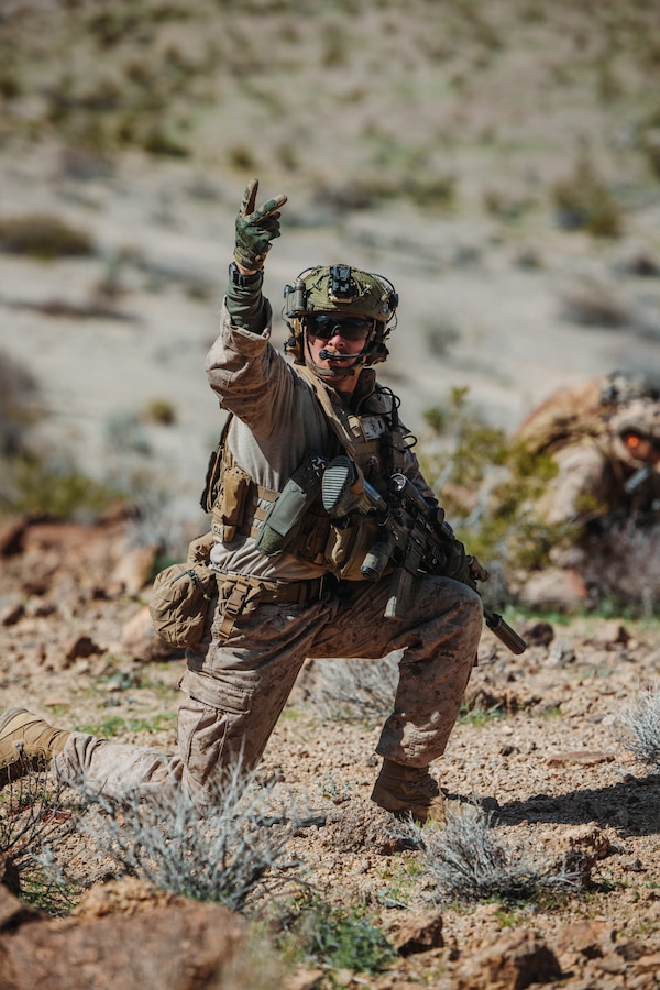 U.S. Marine Corps 1st Lt. David Phipps, a Bloomington, Illinois native, platoon commander with Charlie Company, 1st Battalion, 4th Marine Regiment, 1st Marine Division, calls for two Marines to assist him during a Marine Air-Ground Task Force Distributed Maneuver Exercise as part of Service Level Training Exercise 2-24 at Marine Corps Air-Ground Combat Center, Twentynine Palms, California, Feb. 15, 2024. MDMX is designed to test the MAGTF’s operational capabilities in austere, multi-domain, offensive and defensive operations against adversaries at a regimental level. (U.S. Marine Corps photo by Lance Cpl. Justin J. Marty)