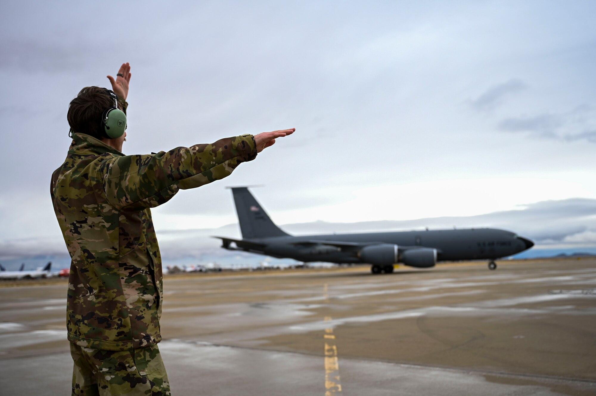 An Air Force officer marshals a jet.