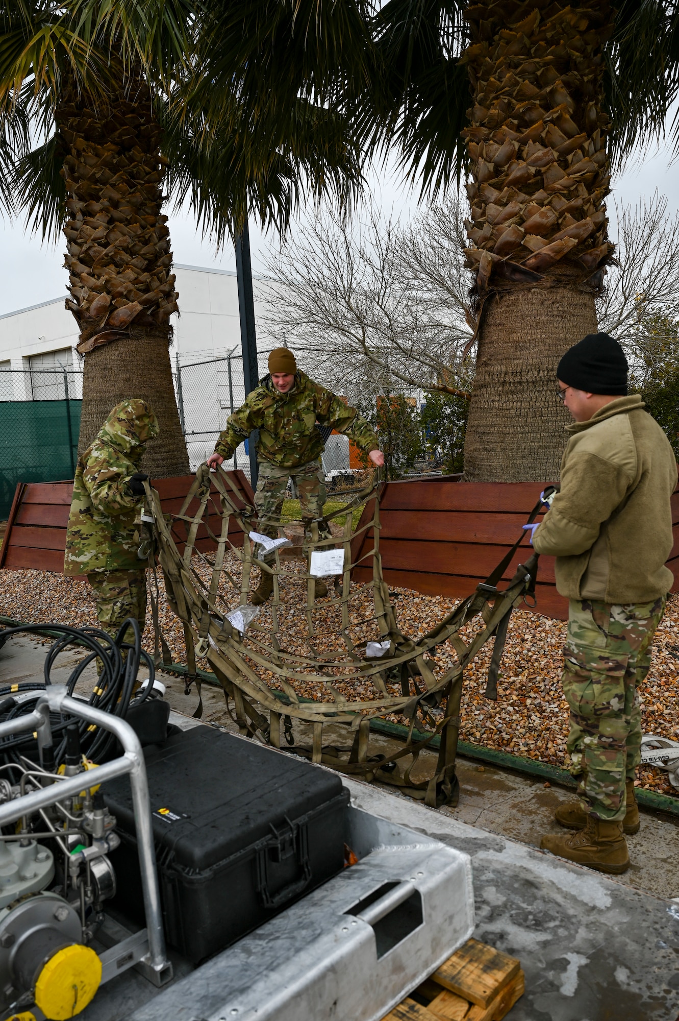 Airmen spread out a cargo net.