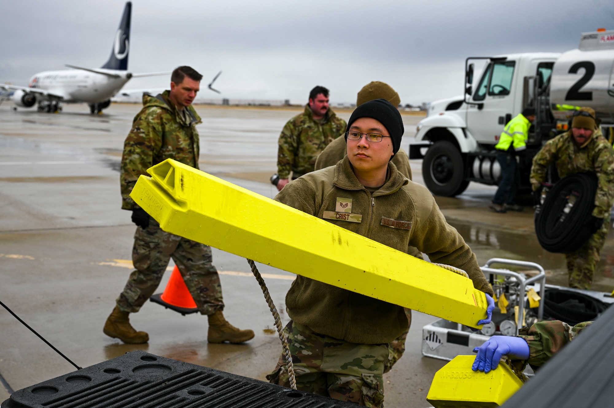 An Airman loads a chock into a truck.